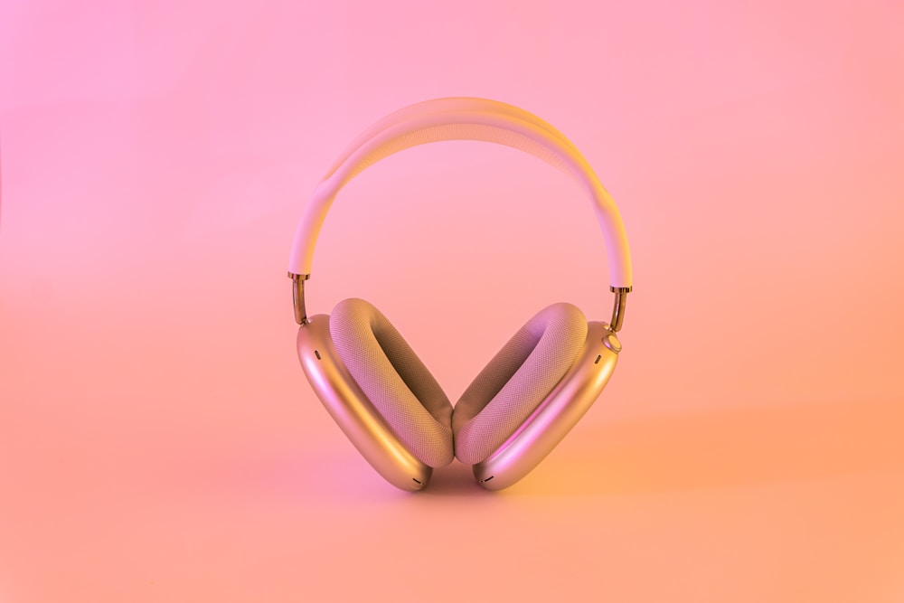 Pink over-ear headphones on a pink studio backdrop