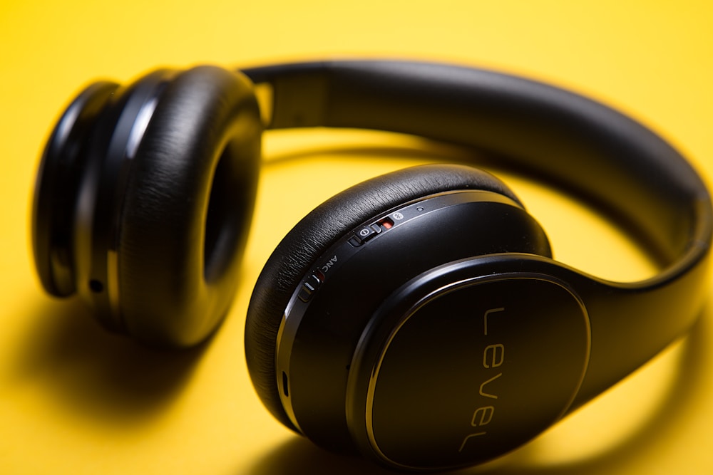Black over-ear headphones on a yellow studio backdrop