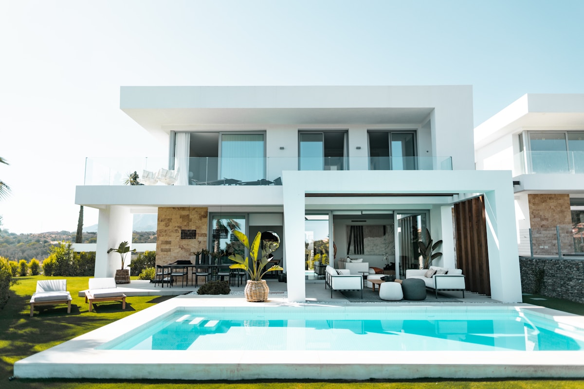 Modern white villa beside a turquoise swimming pool